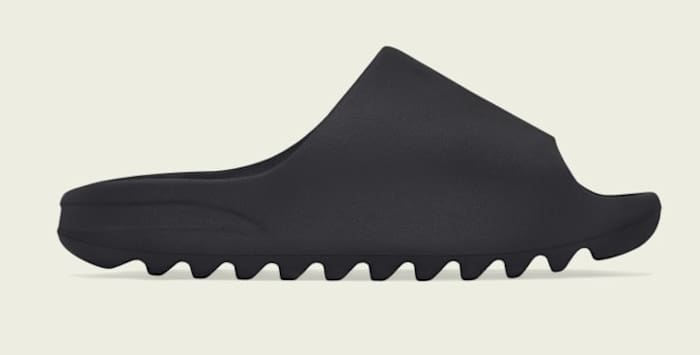 Side view of black adidas Yeezy slide.